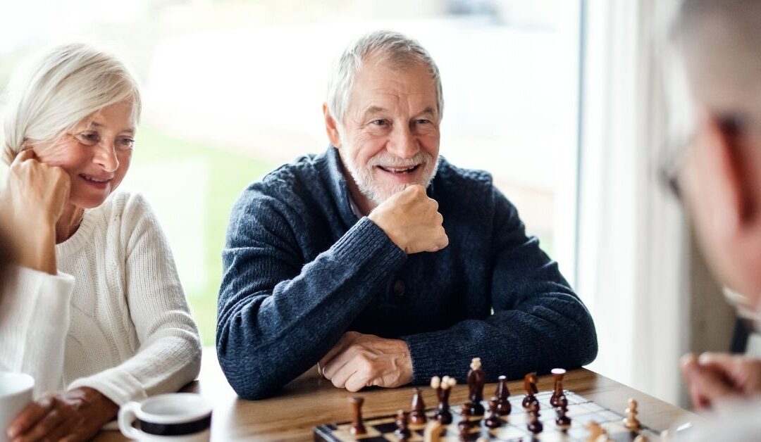 äldre personer som spelar schack med vänner